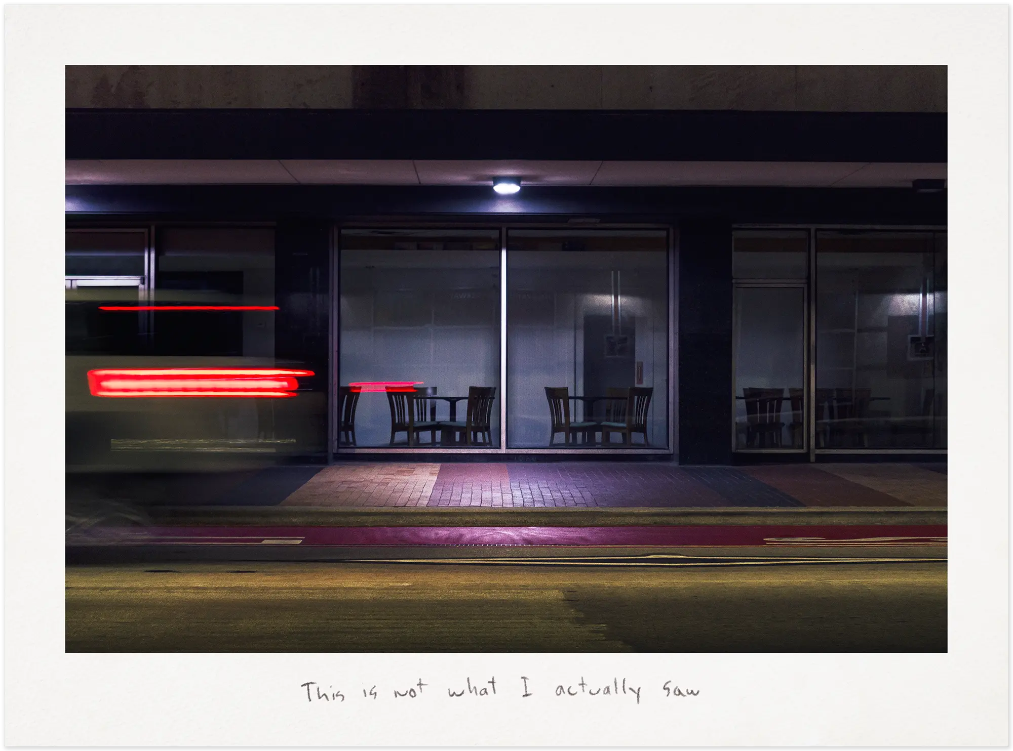 Car passing in front of a downtown diner at night.