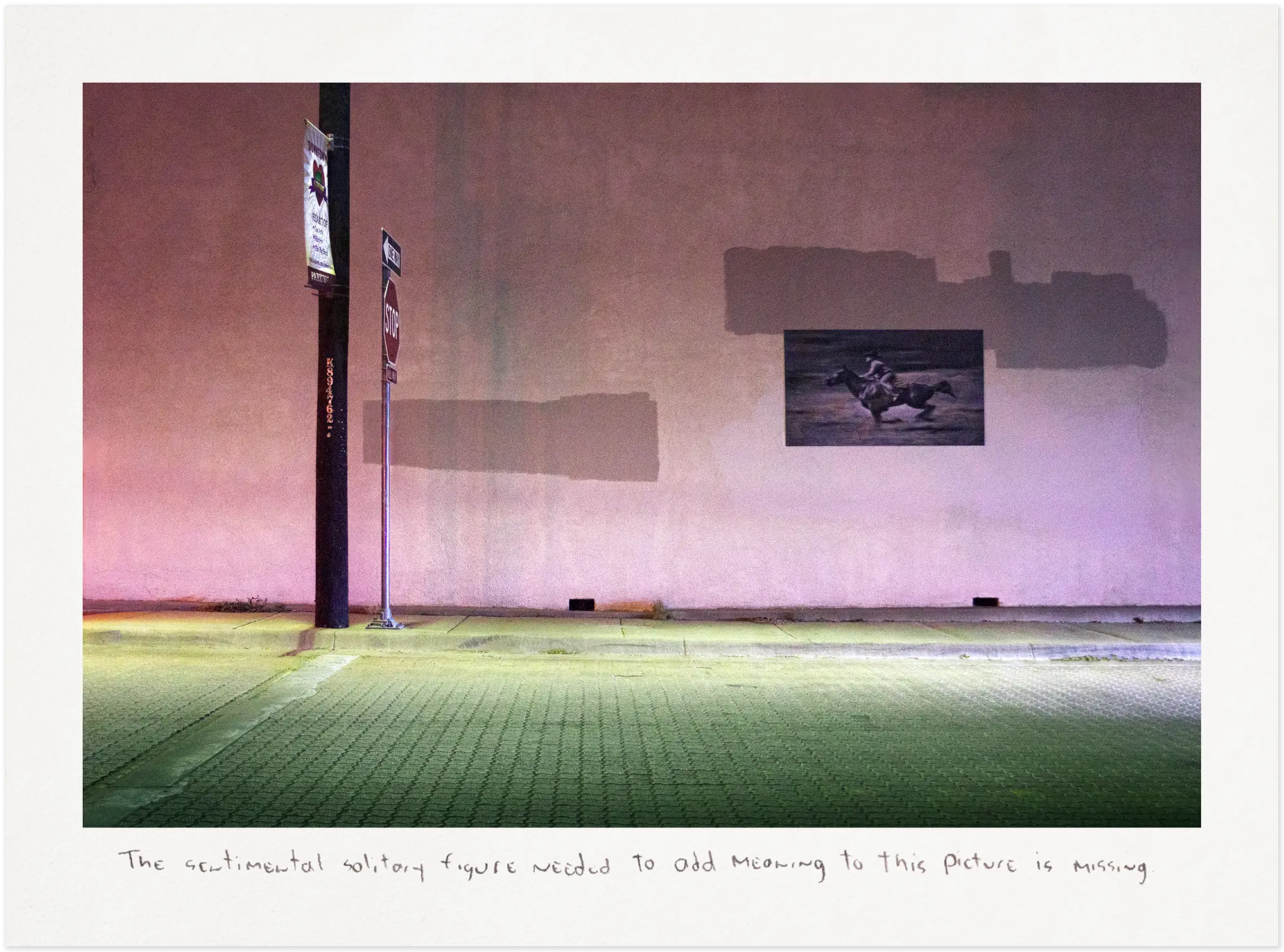 Pink wall with horse graffiti at night.