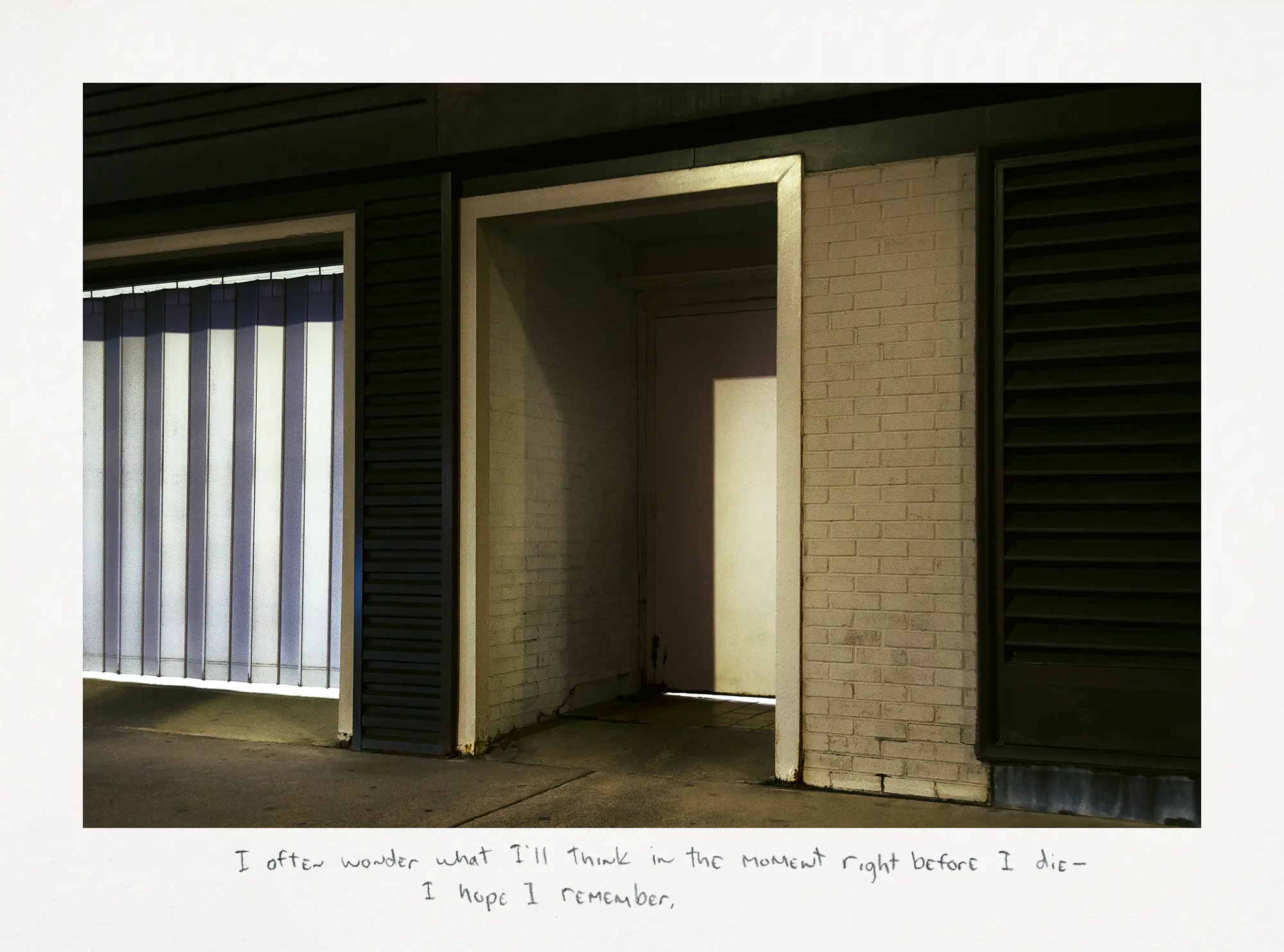 Photograph taken at night where a shadow conceals a recessed door on the city street.