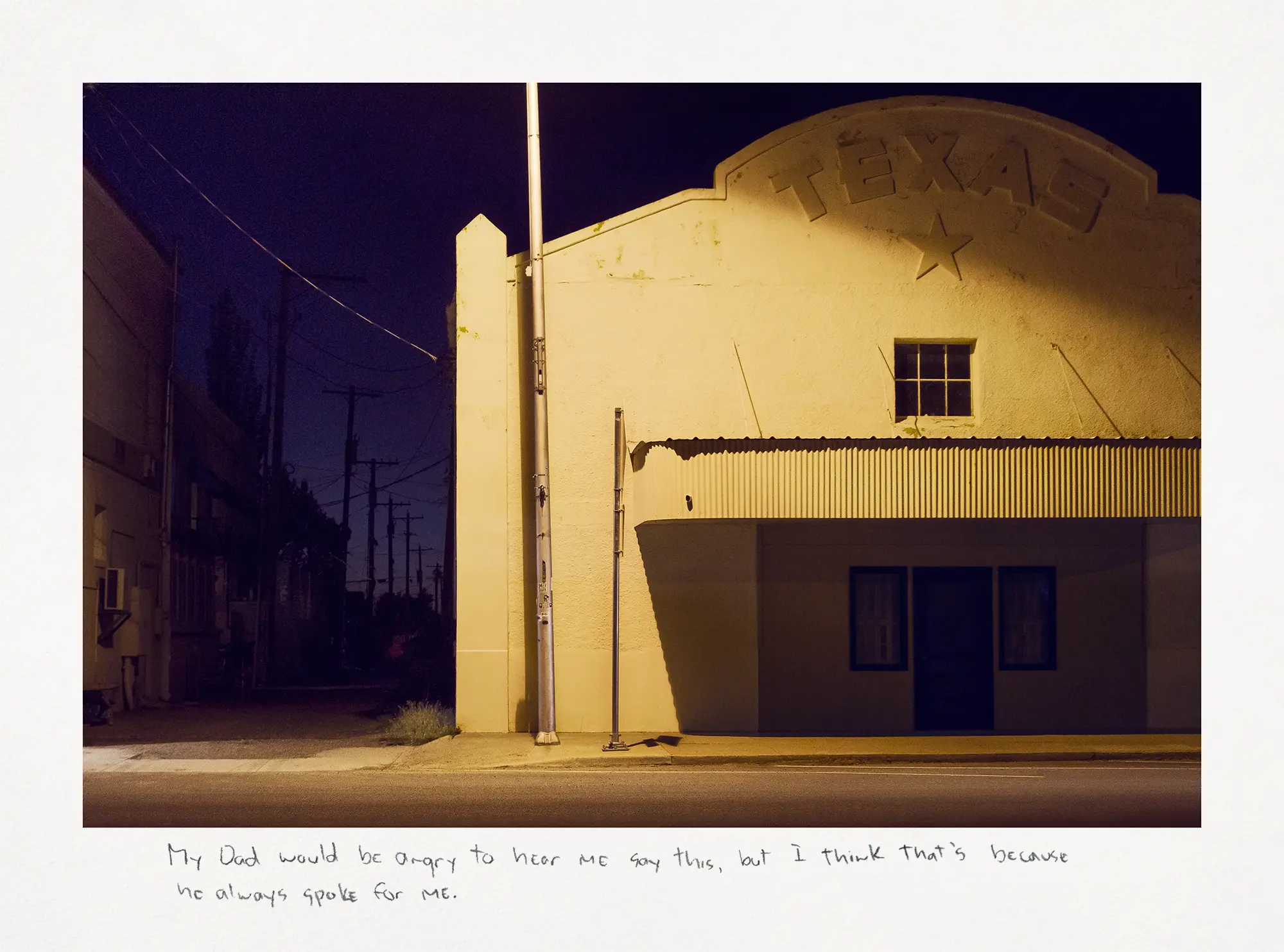 A night photograph depicts a white building with "Texas" clearly visible on its facade, illuminated by a warm orange light.